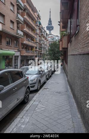 Ein Bürgersteig in einer normalen Straße in der Nähe des Telekommunikationsturms in Madrid, Spanien Stockfoto