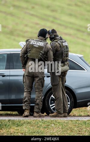 Unterkirnach, Deutschland. Januar 2024. Mitglieder einer Special Police Task Force (SEK) diskutieren über ein ziviles Polizeifahrzeug. Da die Räumung zu eskalieren drohte, setzt die Polizei derzeit ein großes Kontingent in Unterkirnach (Bezirk Schwarzwald-Baar) ein. Laut einer Aussage widersetzte sich ein Mann der Räumung am Dienstagmorgen und drohte, sein Haus niederbrennen zu lassen. Die Polizei sperrte das Haus ab und evakuierte umliegende Gebäude. Quelle: Silas Stein/dpa/Alamy Live News Stockfoto