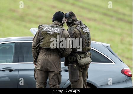 Unterkirnach, Deutschland. Januar 2024. Mitglieder einer Special Police Task Force (SEK) diskutieren über ein ziviles Polizeifahrzeug. Da die Räumung zu eskalieren drohte, setzt die Polizei derzeit ein großes Kontingent in Unterkirnach (Bezirk Schwarzwald-Baar) ein. Laut einer Aussage widersetzte sich ein Mann der Räumung am Dienstagmorgen und drohte, sein Haus niederbrennen zu lassen. Die Polizei sperrte das Haus ab und evakuierte umliegende Gebäude. Quelle: Silas Stein/dpa/Alamy Live News Stockfoto