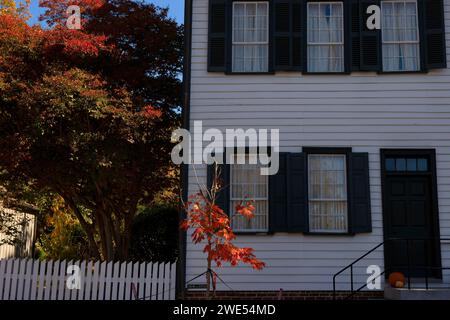 Old Salem, North Carolina, USA - 26. Oktober 2023: Ein 1827 erbauter Abschnitt des Hall-Hauses mit einem Pfahlzaun und herbstfarbenen Bäumen. Stockfoto