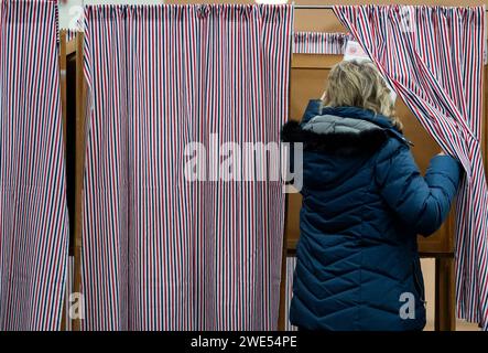 Windham, Usa. Januar 2024. Eine Frau tritt am 23. Januar 2024 in eine Wahlkabine ein, um in der New Hampshire Primary an einer Wahlstelle an der Windham High School in Windham, New Hampshire, zu wählen. Der Republikaner Haley hofft, den ehemaligen US-Präsidenten Donald J. Trump bei den Umfragen in New Hampshire zu besiegen, während der Demokrat Dean Phillips hofft, an Dynamik gegen Präsident Joe Biden gewinnen zu können . Foto: Amanda Sabga/UPI Credit: UPI/Alamy Live News Stockfoto