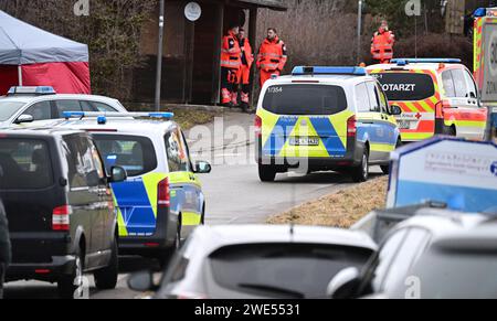 Unterkirnach, Deutschland. Januar 2024. Rettungskräfte stehen neben Polizeifahrzeugen in einem Wohngebiet. Da die Räumung zu eskalieren drohte, setzt die Polizei derzeit ein großes Kontingent in Unterkirnach (Bezirk Schwarzwald-Baar) ein. Laut einer Aussage widersetzte sich ein Mann der Räumung am Dienstagmorgen und drohte, sein Haus niederbrennen zu lassen. Die Polizei sperrte das Haus ab und evakuierte umliegende Gebäude. Quelle: Bernd Weißbrod/dpa/Alamy Live News Stockfoto