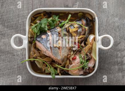 Thailändisch-chinesischer Lachs mit Sojasauce und Ingwer. Zu den Zutaten gehören Zwiebeln, Ingwer, Pilze, rote Chili, Koriander und leichte Sojasauce, H Stockfoto