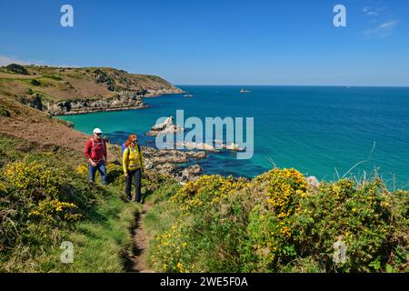 Mann und Frau Wandern auf dem Zöllnerweg bei Cap Sizun mit Meer und felsigen Inseln im Hintergrund, Cap-Sizun, GR 34, Zöllnerweg, Bretagne, Frankreich Stockfoto