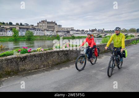 Mann und Frau Radfahren mit Château d&#39; Schloss Amboise und Loire im Hintergrund, Amboise, Loire-Radweg, Loire-Schlösser, Loire-Tal, UNESCO W Stockfoto