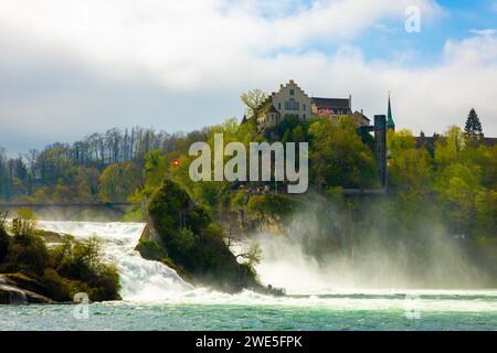 Rheinfall und Schweizer Flagge mit Schloss Laufen bei Neuhausen in Schaffhausen, Schweiz. Stockfoto