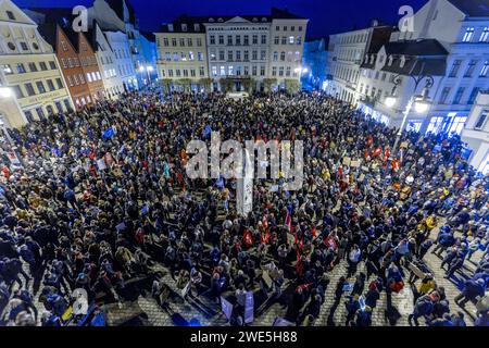 Schwerin, Deutschland. Januar 2024. Teilnehmer einer Demonstration gegen Rechtsextremismus unter dem Motto „Never Again is now! - Gegen die rechte Agitation und Abschiebepläne auf dem Marktplatz. Mit dieser Aktion wollen die Bewohner ein Beispiel für Widerstand gegen rechtsextreme Aktivitäten setzen. Quelle: Jens Büttner/dpa/Alamy Live News Stockfoto