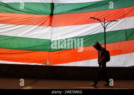 Srinagar Kaschmir, Indien. Januar 2024. Ein Mann läuft an einem riesigen Indianer-Dreifarbig in Srinagar vorbei. Der Tag der Republik in Indien erinnert an die Verabschiedung der Verfassung und den Übergang des Landes zu einer Republik am 26. Januar 1950, wobei jedes Jahr am selben Tag gefeiert wird. Am 23. Januar 2024 In Srinagar Kaschmir, Indien. (Kreditbild: © Firdous Nazir/OKULARIS via ZUMA Press Wire) NUR REDAKTIONELLE VERWENDUNG! Nicht für kommerzielle ZWECKE! Stockfoto