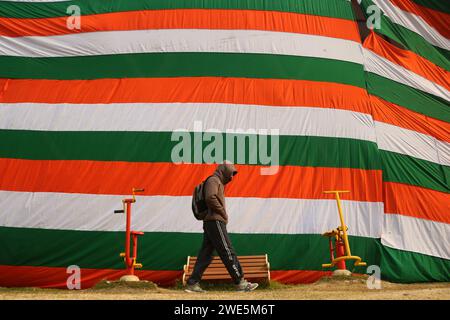 Srinagar Kaschmir, Indien. Januar 2024. Ein Mann läuft an einem riesigen Indianer-Dreifarbig in Srinagar vorbei. Der Tag der Republik in Indien erinnert an die Verabschiedung der Verfassung und den Übergang des Landes zu einer Republik am 26. Januar 1950, wobei jedes Jahr am selben Tag gefeiert wird. Am 23. Januar 2024 In Srinagar Kaschmir, Indien. (Kreditbild: © Firdous Nazir/OKULARIS via ZUMA Press Wire) NUR REDAKTIONELLE VERWENDUNG! Nicht für kommerzielle ZWECKE! Stockfoto