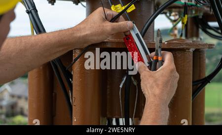 Person, die auf einer Hubmaststelle in Höhe arbeitet Stockfoto