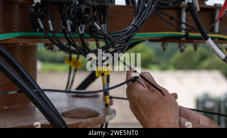 Person, die auf einer Hubmaststelle in Höhe arbeitet Stockfoto