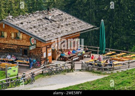 Mehrere Personen sitzen an der Erfrischungsstation Litzlalm, Litzlalm, Berchtesgadener Alpen, Salzburg, Österreich Stockfoto