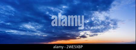 Wunderschöner natürlicher Himmel Hintergrund bei Sonnenuntergang mit dunklen Wolken. Stockfoto