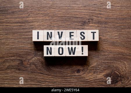 Jetzt investieren – Wortkonzept auf Bausteinen, Text Stockfoto