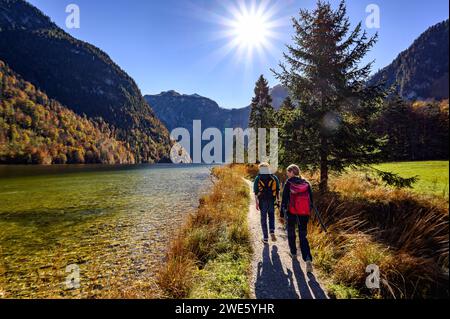 Wandern am Ufer, touristische Bootsfahrt/Schifffahrt am Königssee, Königssee mit St. Bartholomä-Kirche vor der Watzmann-Ostmauer, Königssee, Stockfoto