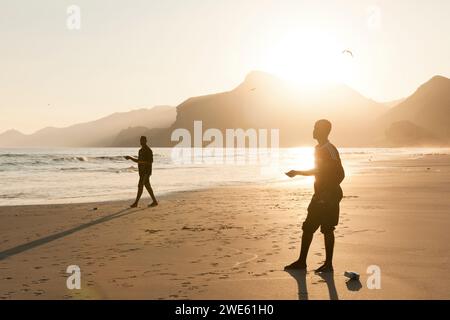 Menschen, die Angeln auf Maghsail Bay Strand bei Sonnenaufgang in Salalah, Dhofar, Oman Stockfoto