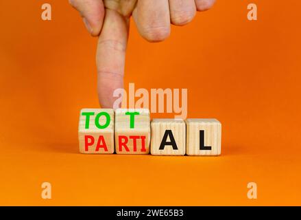 Symbol „Gesamt“ oder „Teil“. Geschäftsmann verwandelt wunderschöne Holzwürfel und ändert das Wort Partial in Total. Schöner oranger Tisch mit orangefarbenem Hintergrund. Bus Stockfoto