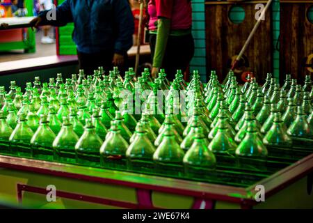 Grüne Glasflaschen in einem Ringwerfen Spiel auf einem Karneval oder einem Jahrmarkt Stockfoto