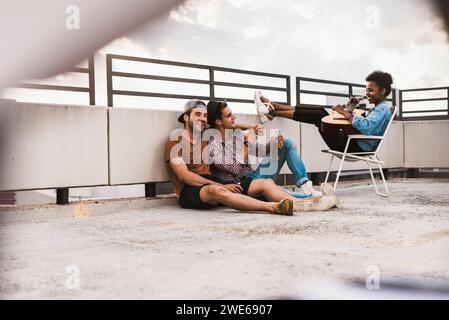 Fröhliche junge Freunde, die auf der Terrasse feiern und Spaß haben Stockfoto