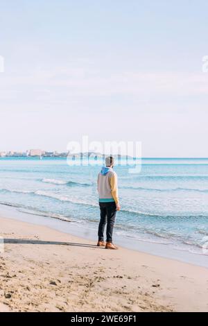 Mann, der in der Nähe des Meeres am Strand steht Stockfoto