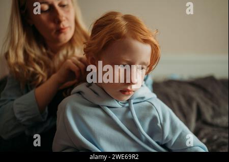 Mutter, die die Haare ihrer Tochter zu Hause geflochten hat Stockfoto