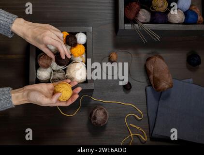 Hände einer Frau, die auf dem Tisch Garnbällen auswählt Stockfoto