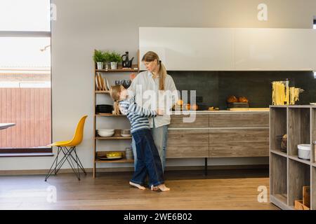 Mutter und Tochter stehen zusammen in der Küche zu Hause. Stockfoto