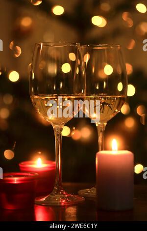 Brennende Kerzen und zwei Gläser Weißwein Stockfoto