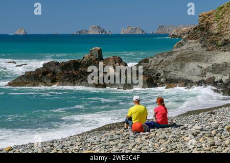 Frankreich, Bretagne, zwei Wanderer, die sich am felsigen Porzh Mel Strand entspannen Stockfoto