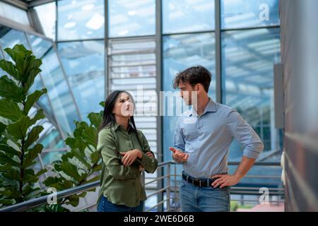 Multirassische Geschäftskollegen diskutieren im Bürokorridor Stockfoto