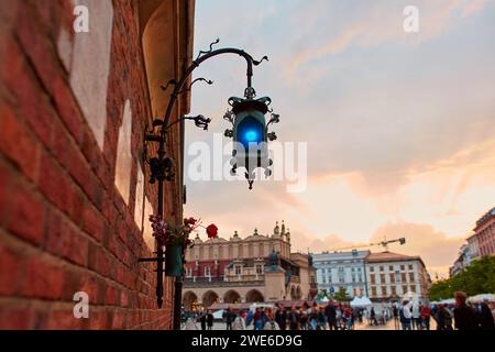 Eine alte blaue Laterne aus handgefertigtem Metall hängt an einer Backsteinmauer in den historischen Straßen von Krakau Stockfoto