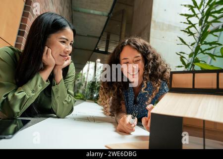 Lächelnder Architekt untersucht Modellhaus mit Kollege im Amt Stockfoto