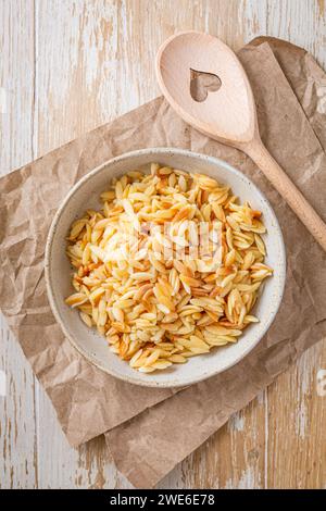 Gekochte italienische Pasta, Risoni, Orzo in einer Schüssel auf Holztisch Stockfoto