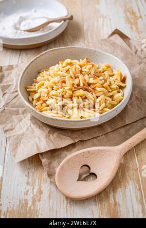 Gekochte italienische Pasta, Risoni, Orzo in einer Schüssel auf Holztisch Stockfoto