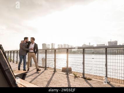 Glückliche Geschäftskollegen, die am Hudson River in New York City vorbeilaufen Stockfoto