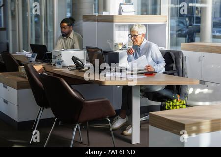 Geschäftskollegen, die gemeinsam am Schreibtisch im Büro arbeiten Stockfoto