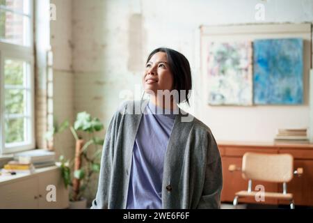 Lächelnder Künstler, der in der Kunstwerkstatt steht Stockfoto