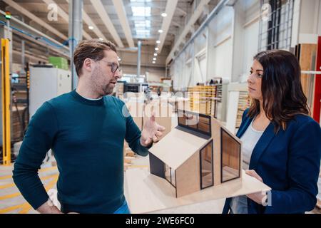 Architekten diskutieren über Modellhaus, das in der Werkstatt steht Stockfoto