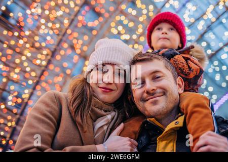 Glückliche Familie, die gemeinsame Freizeit auf dem Weihnachtsmarkt verbringt Stockfoto