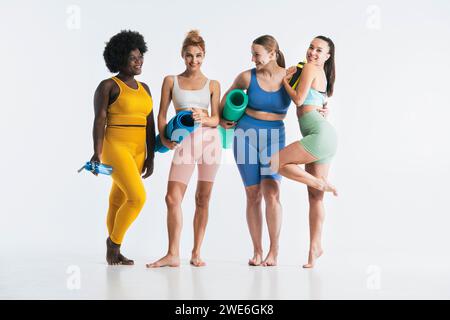 Freunde mit Yogamatten und Wasserflaschen vor weißem Hintergrund Stockfoto