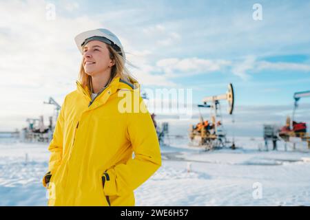 Lächelnder Ingenieur, der im Winter auf dem Ölförderfeld steht Stockfoto