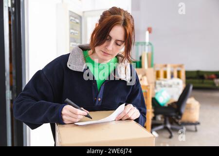 Liefererin, die Papiere für das Paket im Verteilerlager macht Stockfoto