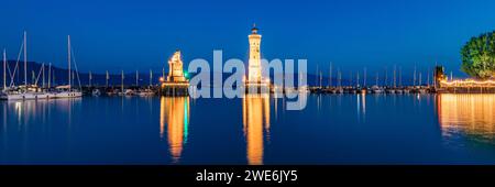 Deutschland, Bayern, Lindau, Stadthafen am Ufer des Bodensees bei Nacht mit Leuchtturm und bayerischer Löwenskulptur im Hintergrund Stockfoto