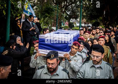 Israelische Offiziere tragen den Sarg von Major Ilay Levy während seiner Beerdigungszeremonie auf dem Militärfriedhof von Tel Aviv. Major Ilay Levi, 24 Jahre alt, wurde in der Schlacht im südlichen Gazastreifen getötet. 24 israelische Soldaten wurden am Montag in Gaza getötet, die bei weitem größte Zahl israelischer Todesopfer im dreimonatigen Krieg gegen die Hamas an einem Tag, da die Gespräche über einen Waffenstillstand intensiviert wurden und die palästinensischen Opfer weiter stiegen.die Todesopfer kamen während heftiger Kämpfe um die südliche Stadt Khan Younis, mit Dutzenden von Palästinensern, die getötet und verletzt wurden. Die israelischen Opfer werden wahrscheinlich die Zahl der inländischen Verluste erhöhen Stockfoto