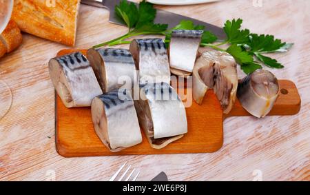 Gesalzene Makrele auf Holzbrett mit Baguette Stockfoto