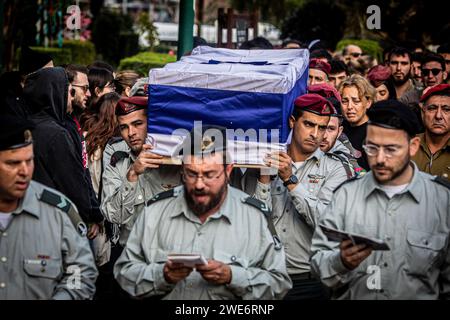 Israelische Offiziere tragen den Sarg von Major Ilay Levy während seiner Beerdigungszeremonie auf dem Militärfriedhof von Tel Aviv. Major Ilay Levi, 24 Jahre alt, wurde in der Schlacht im südlichen Gazastreifen getötet. 24 israelische Soldaten wurden am Montag in Gaza getötet, die bei weitem größte Zahl israelischer Todesopfer im dreimonatigen Krieg gegen die Hamas an einem Tag, da die Gespräche über einen Waffenstillstand intensiviert wurden und die palästinensischen Opfer weiter stiegen.die Todesopfer kamen während heftiger Kämpfe um die südliche Stadt Khan Younis, mit Dutzenden von Palästinensern, die getötet und verletzt wurden. Die israelischen Opfer dürften die Zahl der Inlandspreise erhöhen Stockfoto