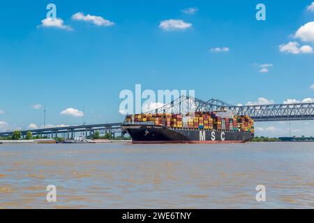 MSC Toronto Fracht-Containerschiff, das unter einer Brücke auf dem Mississippi River in New Orleans, Louisiana, vorbeifährt Stockfoto
