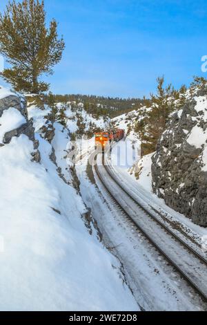 Der Zug unter mullan fährt im Winter über die kontinentale Wasserscheide in der Nähe von austin, montana Stockfoto