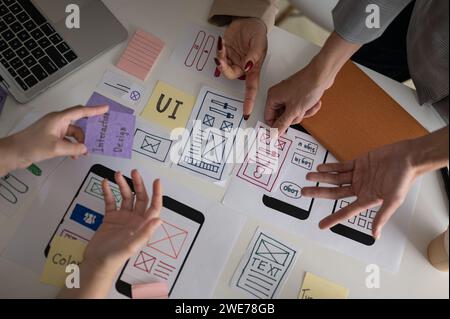 Draufsicht eines professionellen und kreativen UX-UI-Grafikdesigner-Teams, das den perfekten Prototyp für sein neues Produkt wählt, diskutiert und plant den Arbeitsauftrag Stockfoto