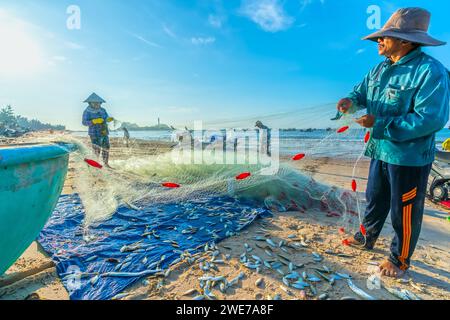 Fischmarkt Session Seeszene Menschen versammelten sich im Korb Fischverkauf, anstrengende Ruderfischer brachten an Land Fischerdorf in Phan Thiet Stockfoto